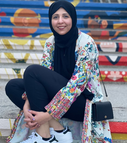 A group of women standing together with political banners in the background.